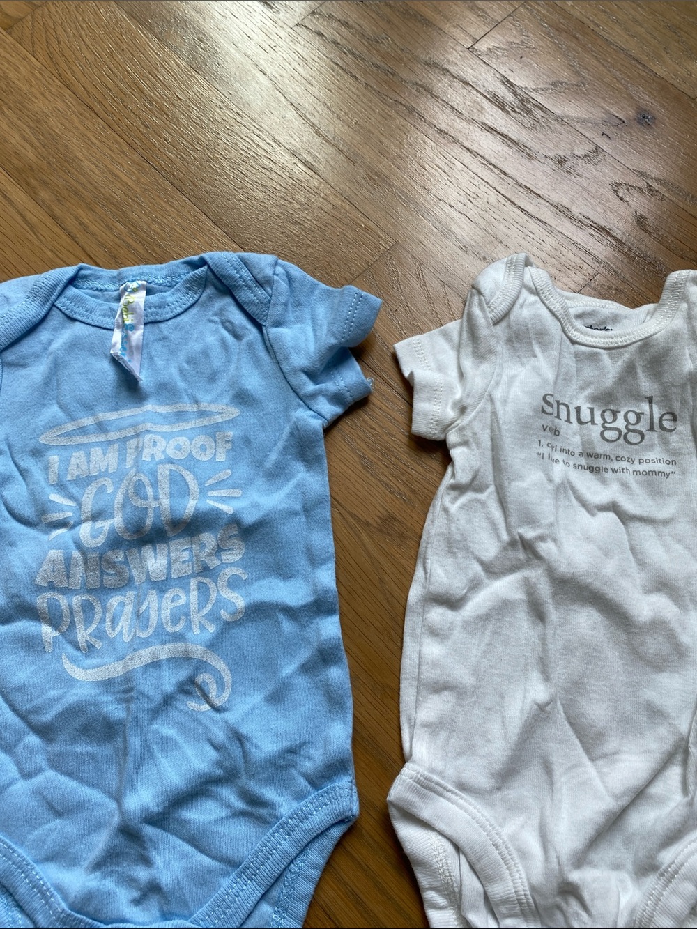 Set of Carter's NB White 'Snuggle' Graphic Bodysuit & ‘God Answers Prayers’